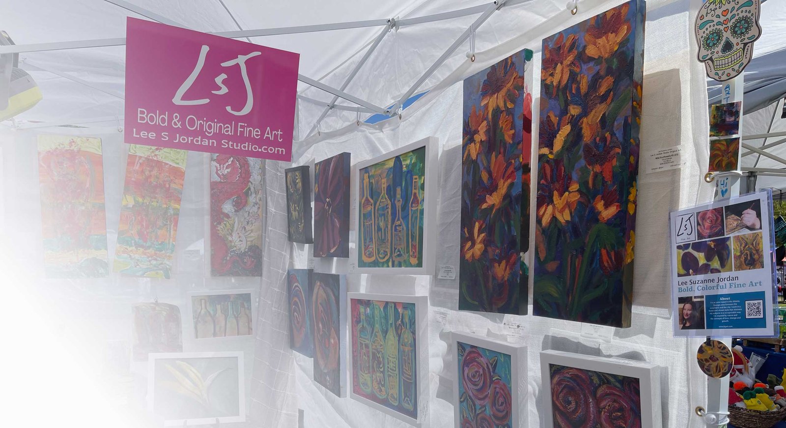 art show booth showing paintings hanging inside a pop up canopy tent